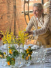 Fiorista durante la preparazione di un allestimento floreale con fiori gialli