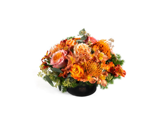 Centrotavola floreale nei toni arancio e pesca con rose e fiori stagionali in flowerbox Antonia Flowers