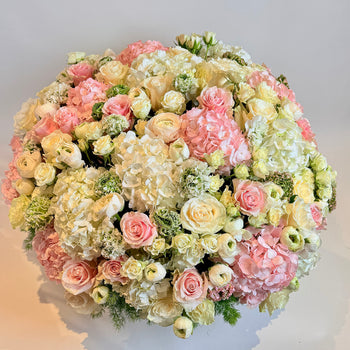 Antonia Flowers Roma, composizione floreale vista dall’alto con ortensie rosa e avorio, rose, ranuncoli e dettagli verdi