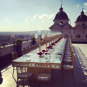 Tavolo imperiale allestito sulla terrazza dell’Hotel Hassler a Roma con composizioni floreali rosse