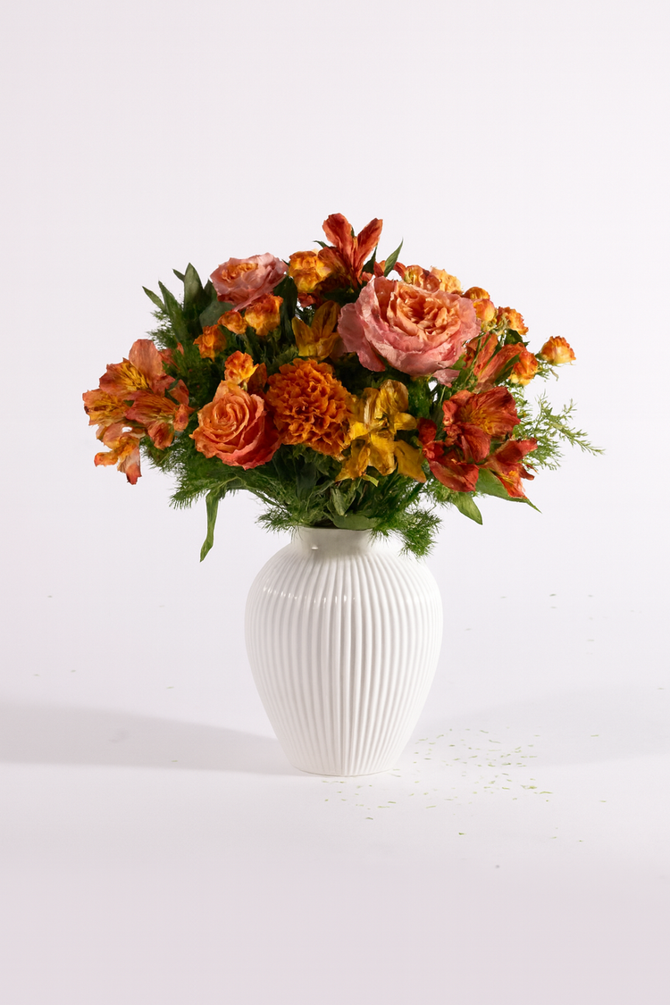 Bouquet autunnale nei toni arancio, rosa e verde con rose e fiori stagionali in vaso bianco