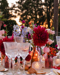 Antonia Flowers Roma, allestimento floreale per cena all’aperto con dalie rosse, fiori rosa, candele e vasi colorati al tramonto