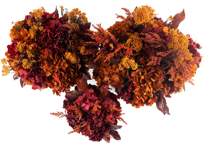 Composizioni Florever con ortensie e fiori stabilizzati nei toni bordeaux, ruggine e arancio