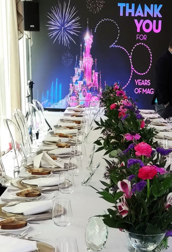 Allestimento floreale per evento Disney al Gran Meliá Roma con fiori rosa e viola su tavolo imperiale