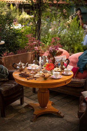 Tea table decorato con fiori nei toni rosa e arancio a Le Serre