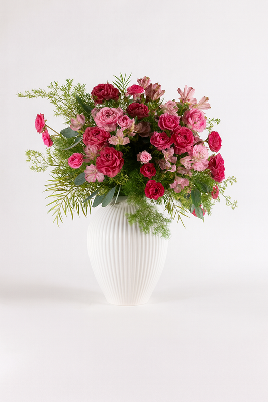 Composizione floreale rosa e fucsia con rose e fiori stagionali in vaso Dionisio bianco